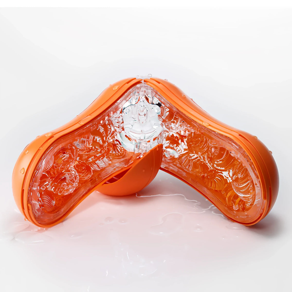 TENGA FLIP ORB Sunset Orange, отворен като V върху мокра бяла повърхност, с видима прозрачна текстурирана вътрешност и оранжев корпус
