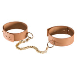 Белезници за крака MAZE на Bijoux Indiscrets: две карамелено кафяви маншета с метални халки, свързани със златиста верижка