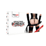 Предна страна на бялата кутия на комплект Amazing Bondage Sex Toy Kit на ToyJoy, с модел в черен корсет, дълги ръкавици и камшик