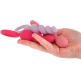 Три силиконови анални стимулатора Satisfyer в розово, лилаво и корал с пръстеновидни дръжки, поставени върху длан за сравнение на размера