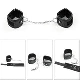 Комплект Deluxe Bondage Kit Black III на Lovetoy: две черни меки маншети със сребристи халки, свързани с метална верижка, и три малки кадъра с детайли