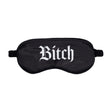 Черна сатенена маска за очи Bitch на Ouch! с ластична лента, отпред с бял готически надпис „Bitch“, на бял фон