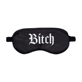 Черна сатенена маска за очи Bitch на Ouch! с ластична лента, отпред с бял готически надпис „Bitch“, на бял фон