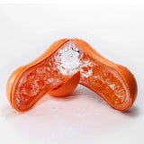 TENGA FLIP ORB Sunset Orange, отворен като V върху мокра бяла повърхност, с видима прозрачна текстурирана вътрешност и оранжев корпус