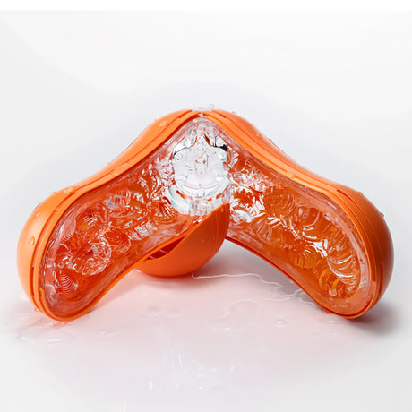 TENGA FLIP ORB Sunset Orange, отворен като V върху мокра бяла повърхност, с видима прозрачна текстурирана вътрешност и оранжев корпус