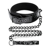 Нашийник Black Sapphire на IntoYou с катарама и капси, закачена метална верига и дръжка от черна лачена кожа с релефен шарен десен