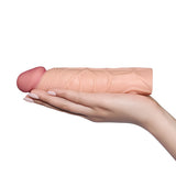 Пенис удължител Pleasure X-Tender в телесен цвят, поставен на дланта на ръка, за показване на размера му