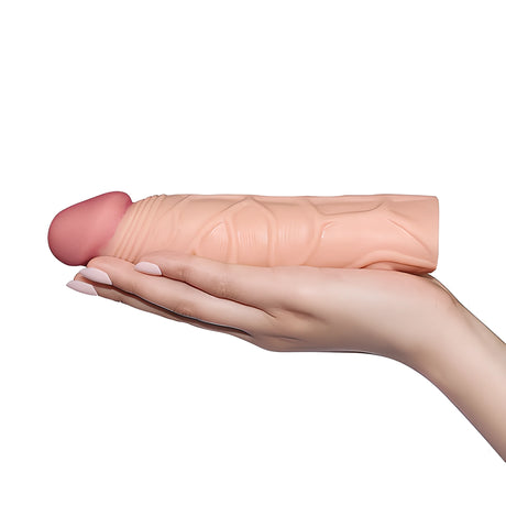 Пенис удължител Pleasure X-Tender в телесен цвят, поставен на дланта на ръка, за показване на размера му