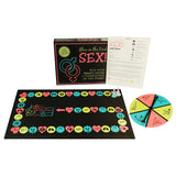 Игра Glow in the Dark Sex на Kheper Games: черна кутия, лист с правила, игрова дъска с цветни полета, фигурки и въртяща се стрелка