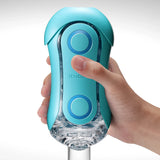 TENGA FLIP ORB Ocean Blue в ръка – отпред се виждат синият корпус с две кръгли бутона и прозрачната долна част