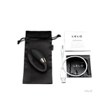 Lelo Noa в черно върху сатенена торбичка, до него бял USB кабел за зареждане, ръководство за употреба и черен пакет с лого на LELO
