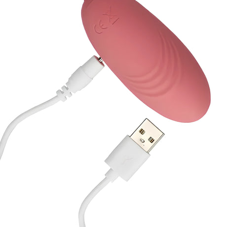 Розово виброяйце Ultra Soft Silicone на Shots с магнитен бял USB кабел за зареждане, поставен до контакта на корпуса
