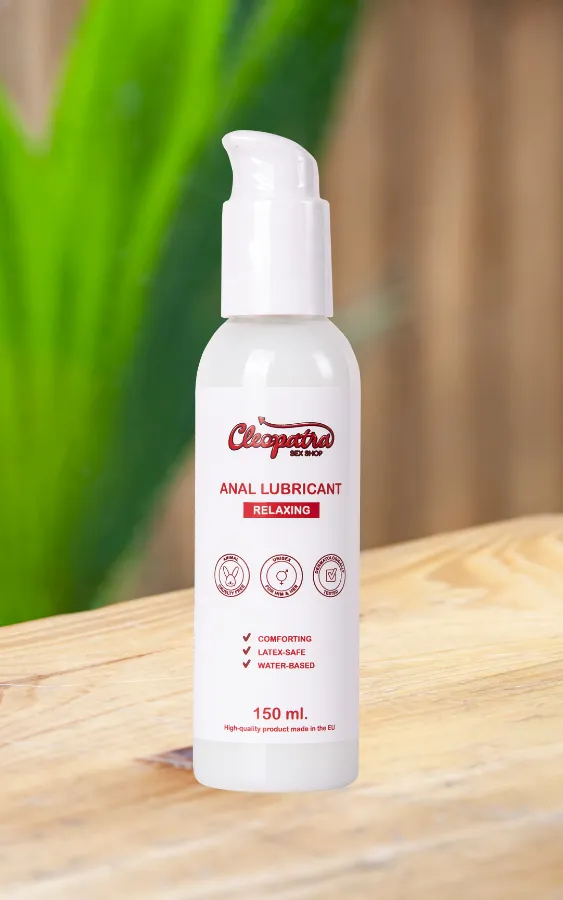 Анален лубрикант Cleopatra Relaxing – 150 мл, комфортен, безопасен за латекс, на водна основа, поставен на дървена повърхност с зеленина на заден план.